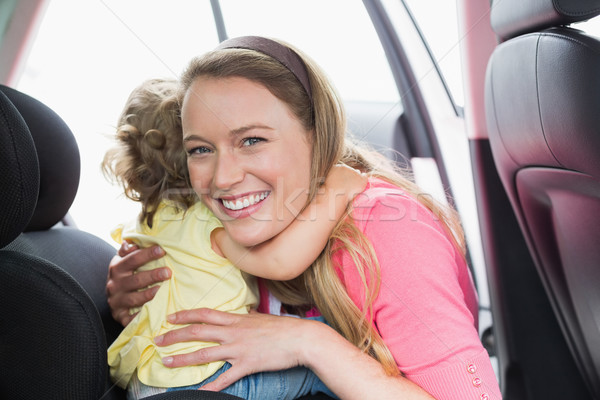 Mother securing her baby in the car seat Stock photo © wavebreak_media