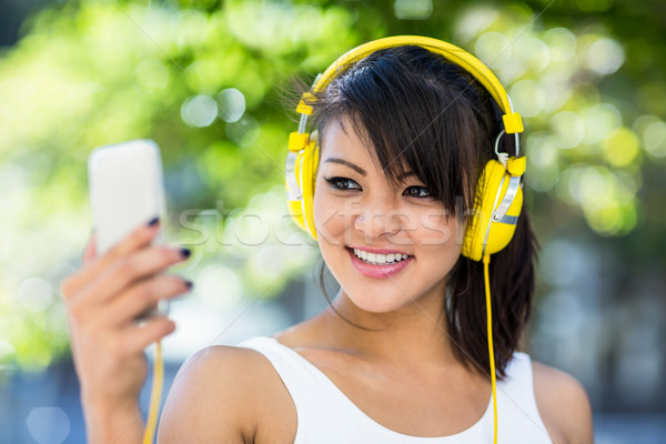 Smiling athletic woman wearing yellow headphones and taking self Stock photo © wavebreak_media