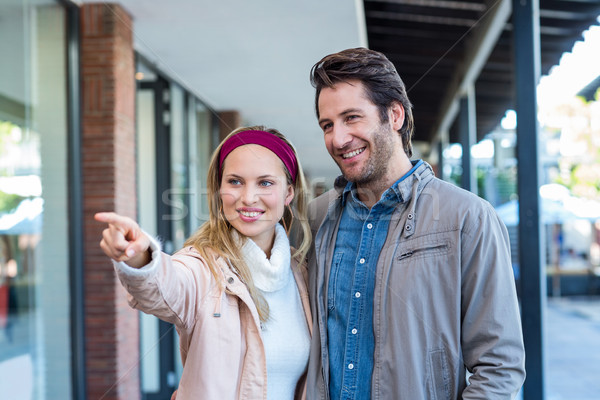 Smiling couple looking and pointing Stock photo © wavebreak_media