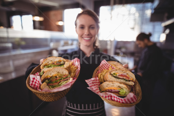 Stock photo: Portrait of smiling young waitress serving fresh burgers at coffee shop