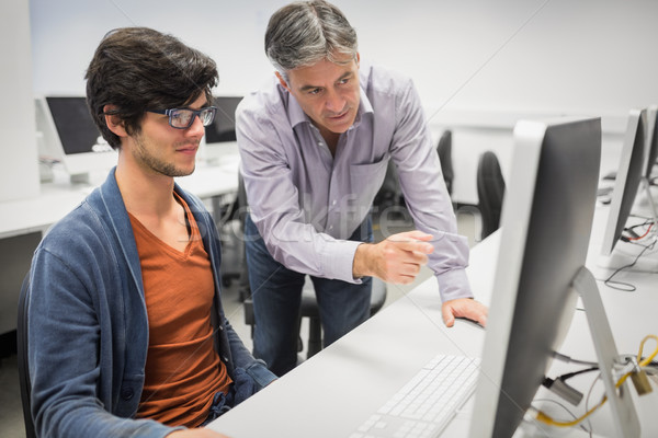 Stock photo: Computer teacher assisting a student