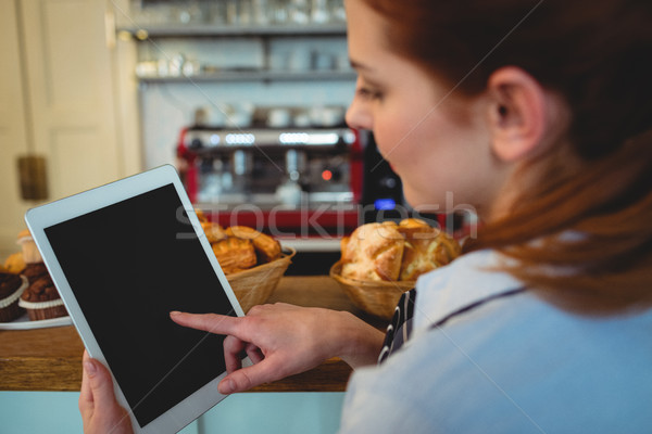 Barista scrolling digital tablet at cafe Stock photo © wavebreak_media