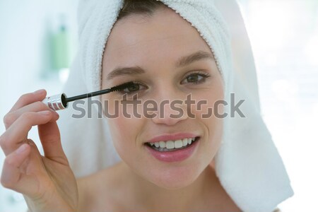 Woman applying mascara on eyelashes in bathroom Stock photo © wavebreak_media
