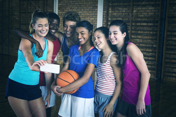 Happy high school team taking a selfie with mobile phone in the court Stock photo © wavebreak_media