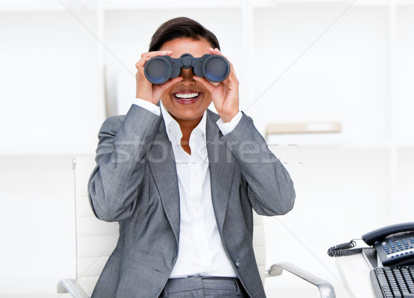 Jolly businesswoman looking through binoculars  Stock photo © wavebreak_media