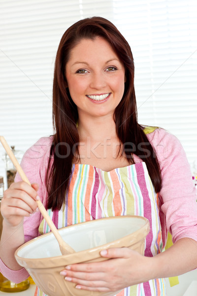 Stock photo: Smiling woman cooking a cake at home