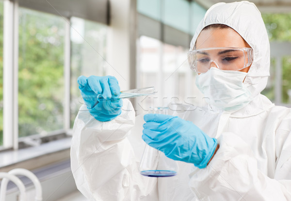 Protected scientist pouring liquid in a laboratory Stock photo © wavebreak_media