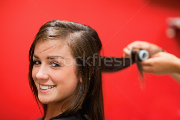 Smiling woman having her hair rolled with a curler Stock photo © wavebreak_media