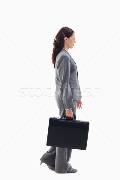Profile of a businesswoman walking with a briefcase against white background Stock photo © wavebreak_media