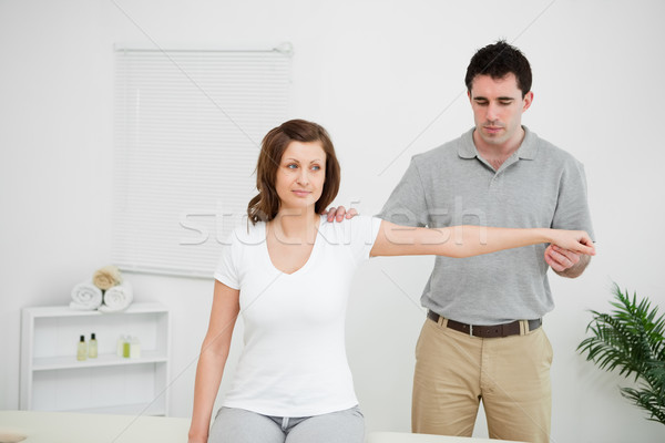 Serious practitioner extending the arm of a patient in a room Stock photo © wavebreak_media