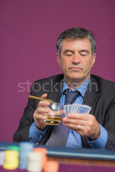 Hombre sesión mirando tarjetas cigarro Foto stock © wavebreak_media