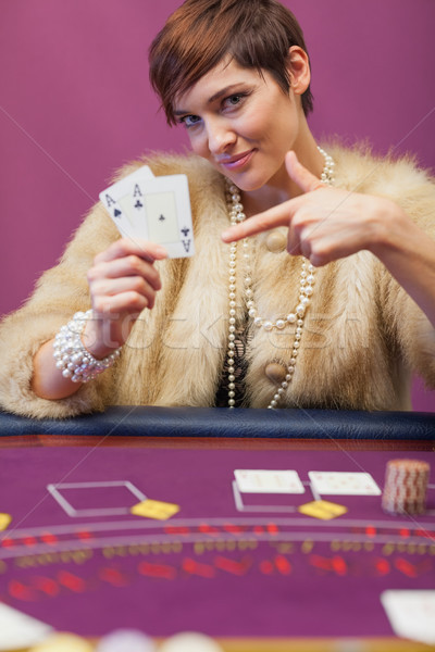 Woman in a casino sitting at table and showing cards Stock photo © wavebreak_media