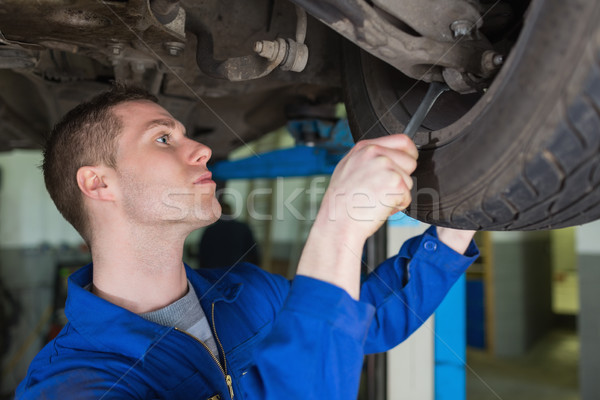 Stock photo: Auto mechanic repairing car with spanner