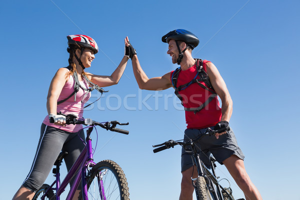 Fit cyclist couple standing at the summit high fiving Stock photo © wavebreak_media