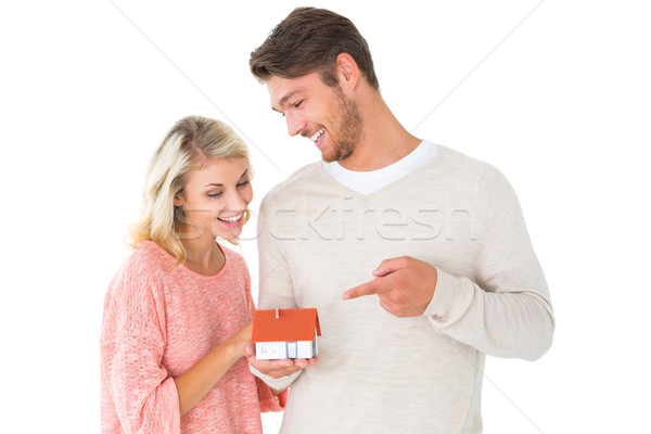 Stock photo: Attractive couple holding miniature house model