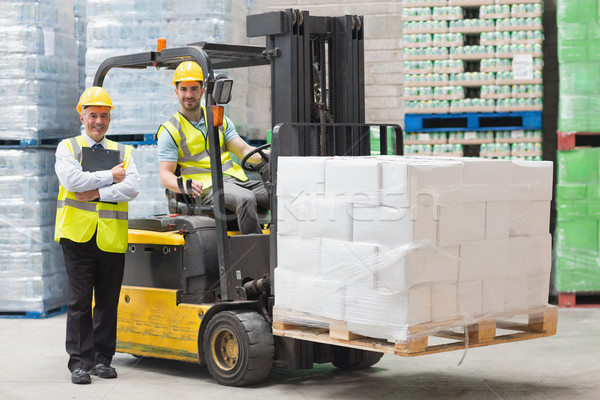 Driver operating forklift machine next to his manager Stock photo © wavebreak_media