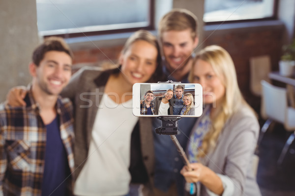 Smiling friends taking selfies with selfiestick  Stock photo © wavebreak_media