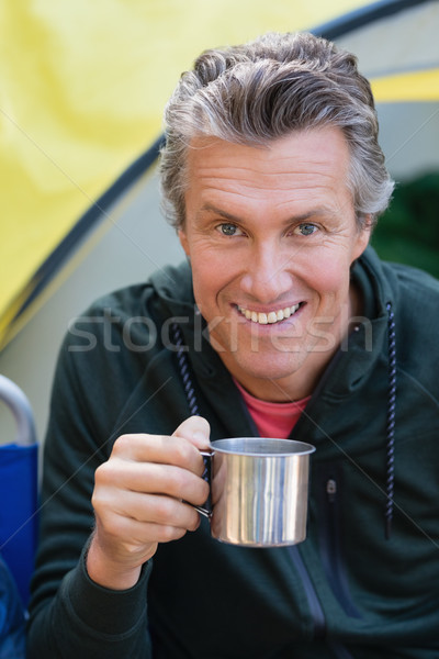 Man holding cup by tent at campsite Stock photo © wavebreak_media