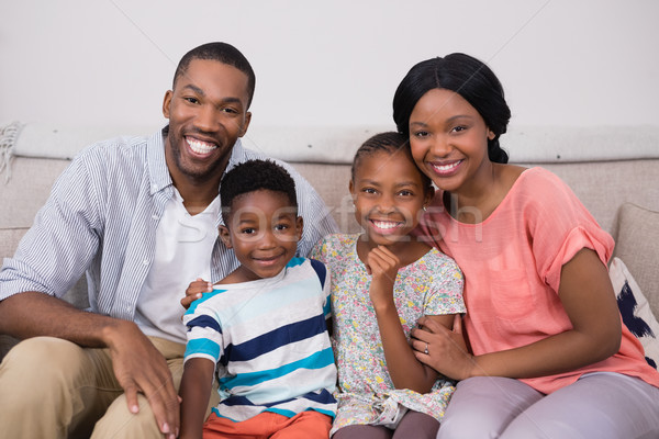 Happy family sitting on sofa at home Stock photo © wavebreak_media