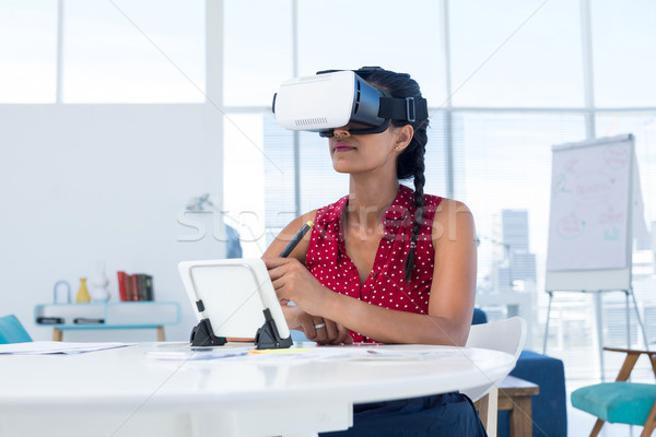 Stock photo: Female graphic designer in virtual reality headset using digital tablet at desk