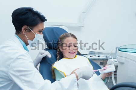 Portrait of cute boy sitting on dentist chair by dentist Stock photo © wavebreak_media