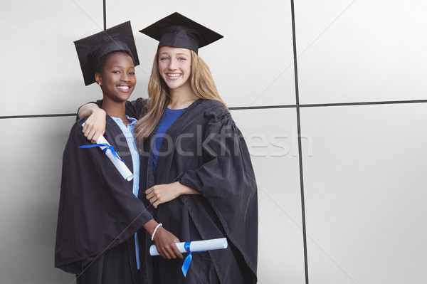 Portrait of happy friends holding degree against white tiling Stock photo © wavebreak_media