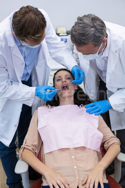 Dentists examining a female patient with tools Stock photo © wavebreak_media