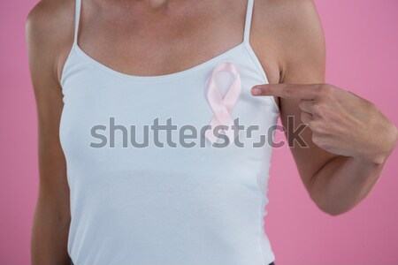 Woman shows pink ribbon for breast cancer awareness on white background Stock photo © wavebreak_media