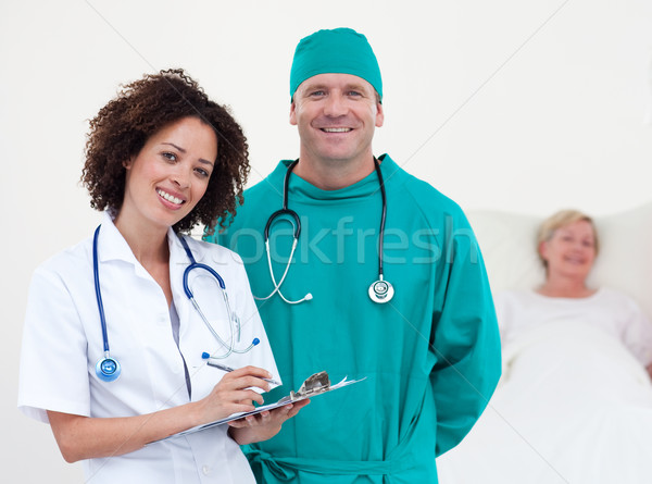 Charismatic team of doctors smiling at camera patient lying in her bed in a hospital Stock photo © wavebreak_media