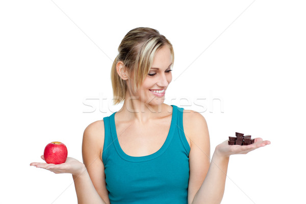 Young woman with an apple in one hand and chocolate in the other one Stock photo © wavebreak_media