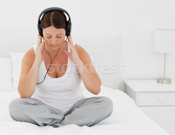 Woman listening to music on her bed at home Stock photo © wavebreak_media