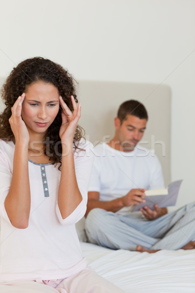 Woman having a headache while her husband is reading Stock photo © wavebreak_media