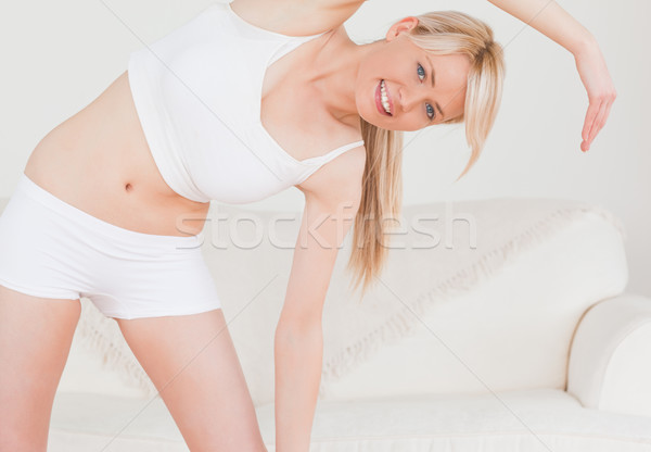 魅力的な ブロンド 女性 ポーズ ストレッチング リビングルーム ストックフォト © wavebreak_media