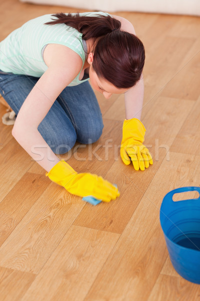 Good looking red-haired woman cleaning the floor while kneeling at home Stock photo © wavebreak_media