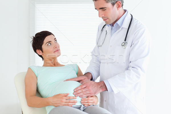 Doctor ausculating a pregnant woman's belly in a room Stock photo © wavebreak_media