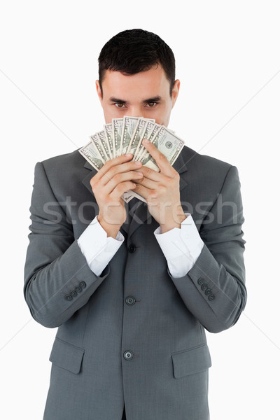 Businessman smelling bank notes against a white background Stock photo © wavebreak_media