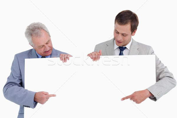 Tradesmen pointing at blank sign in their hands against a white background Stock photo © wavebreak_media