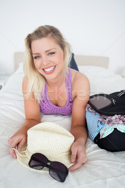 Smiling blonde with suitcase on her bed Stock photo © wavebreak_media