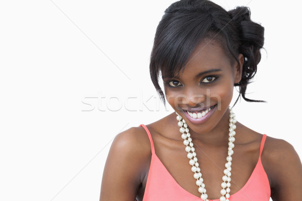 Woman standing wearing a pearl necklace smiling against white background Stock photo © wavebreak_media