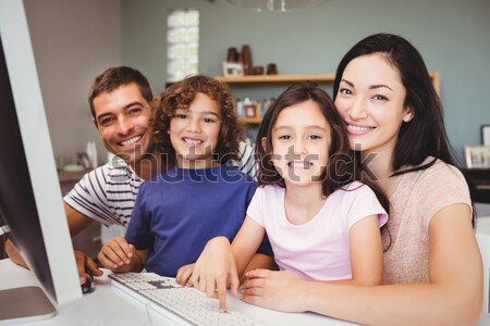 Happy family looking at the camera with a laptop Stock photo © wavebreak_media