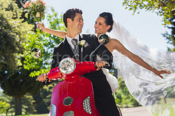 Newlywed couple sitting on scooter in park Stock photo © wavebreak_media
