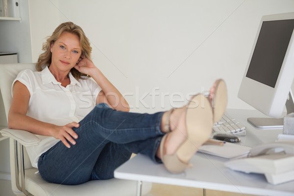 Casual mujer de negocios sesión escritorio pies hasta Foto stock © wavebreak_media