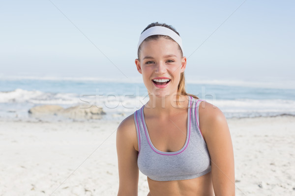 Sporty blonde on the beach smiling at camera Stock photo © wavebreak_media