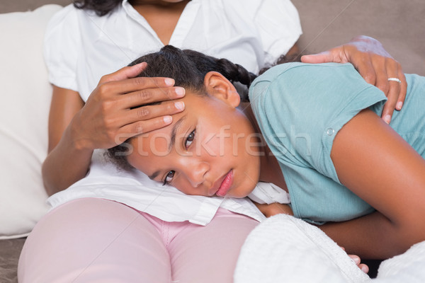 Sick daughter lying on mothers lap Stock photo © wavebreak_media