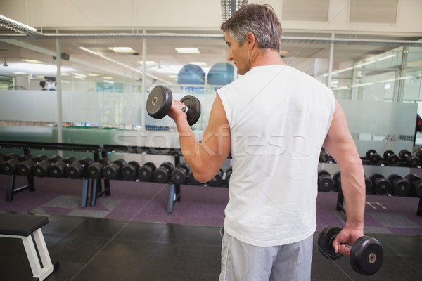 Fit man lifting heavy black dumbbell Stock photo © wavebreak_media