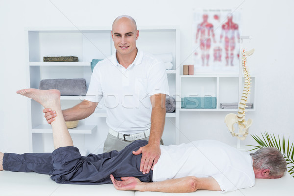 Stock photo: Physiotherapist doing leg massage to his patient