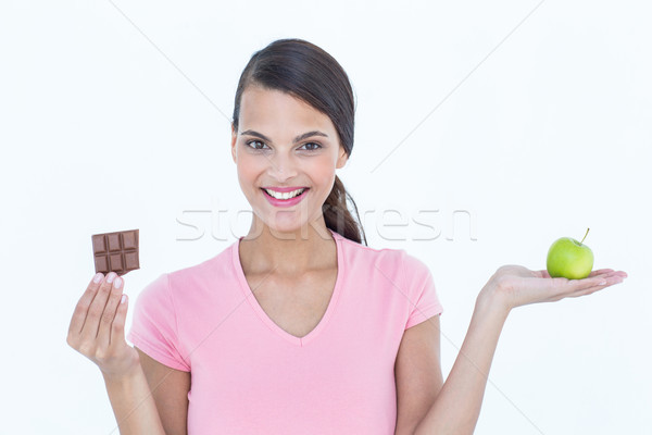 Pretty woman holding chocolate bars and an apple  Stock photo © wavebreak_media