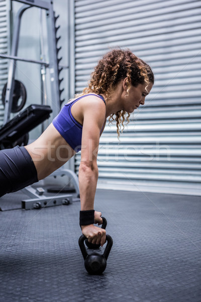 Muscular woman doing push-ups with kettlebells Stock photo © wavebreak_media