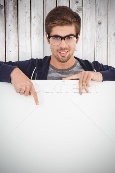 Composite image of portrait of man wearing eyeglasses pointing o Stock photo © wavebreak_media