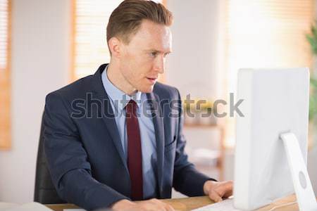 Stylish businessman working at his desk Stock photo © wavebreak_media